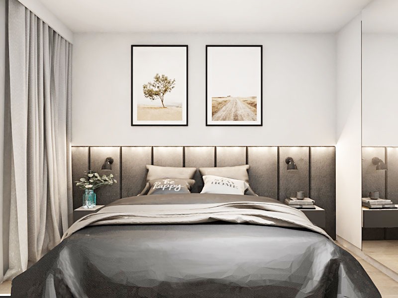 Nowoczesna sypialnia z szarą tapicerowaną ścianą za łóżkiem, dwoma obrazami z motywami pejzażowymi nad wezgłowiem, minimalistycznymi lampkami nocnymi i dekoracyjnymi poduszkami.