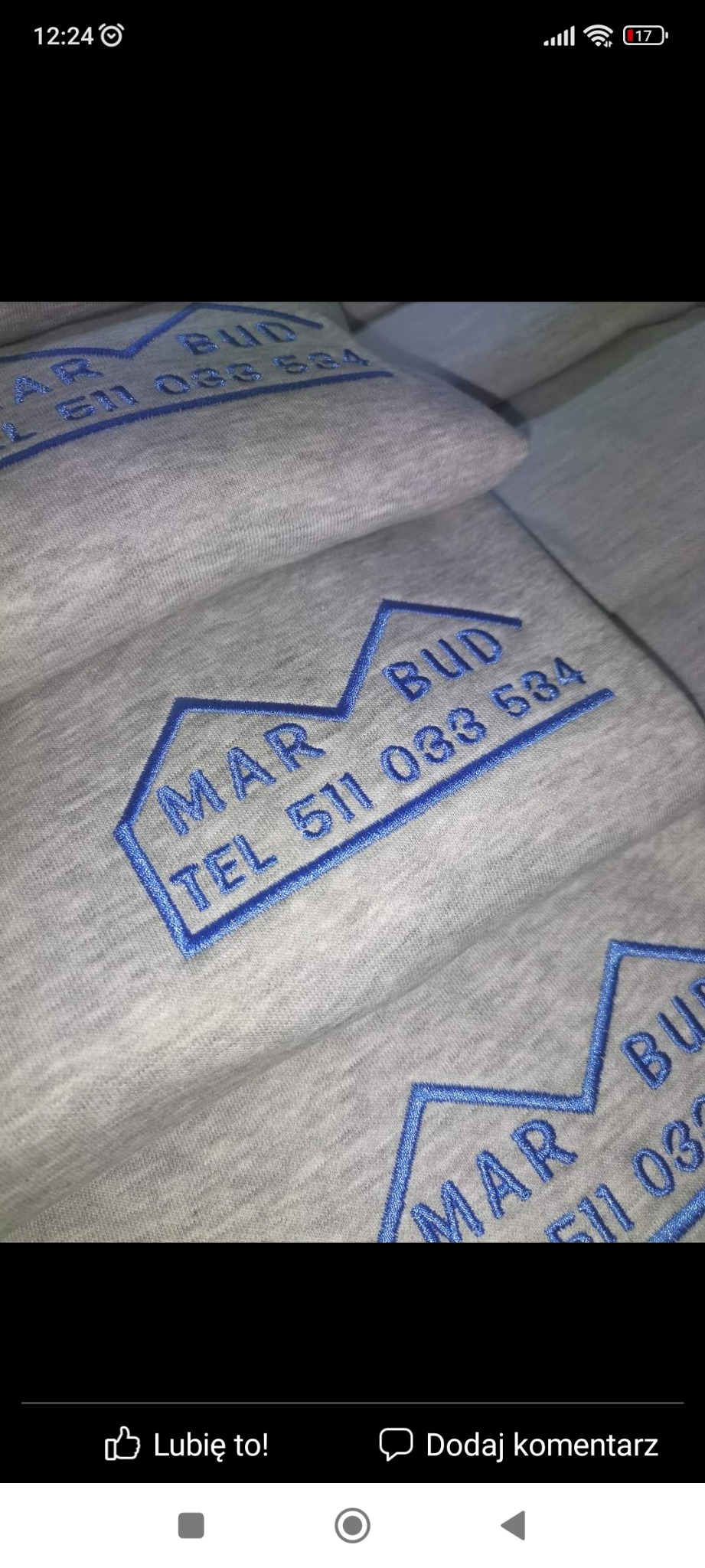 Stos szarych bluz z wyhaftowanym niebieskim logo firmy budowlanej 'MAR BUD' i numerem telefonu 511 033 634.