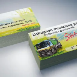 Stos wizytówek z nadrukiem: z jednej strony oferta sprzedaży pasz, z drugiej usługi mieszania pasz z ilustracją ciężarówki śrutownika.