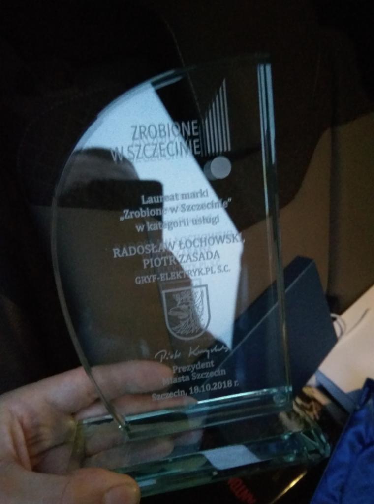 Szklana statuetka z napisem 'Zrobione w Szczecinie' dla firmy GRYF-ELEKTRYK.PL S.C., laureata w kategorii usługi, z podpisem Prezydenta Miasta Szczecin.