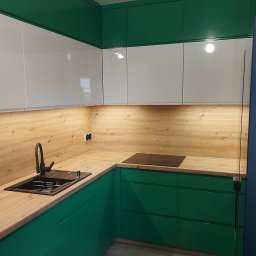 Firma Handlowo Usługowa Meblo-Man Krystian Babiarz - Nowoczesna kuchnia z zielonymi szafkami dolnymi i białymi górnymi, drewniany blat, czarny zlew i bateria, oświetlenie podszafkowe