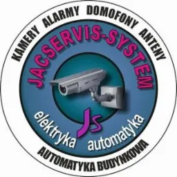 Okrągłe logo firmy JACSERVIS-SYSTEM w kolorach niebieskim, białym i czarnym, przedstawiające kamerę przemysłową, napisy 'KAMERY ALARMY DOMOFONY ANTENY elektryka automatyka AUTOMATYKA BUDYNKOWA'...