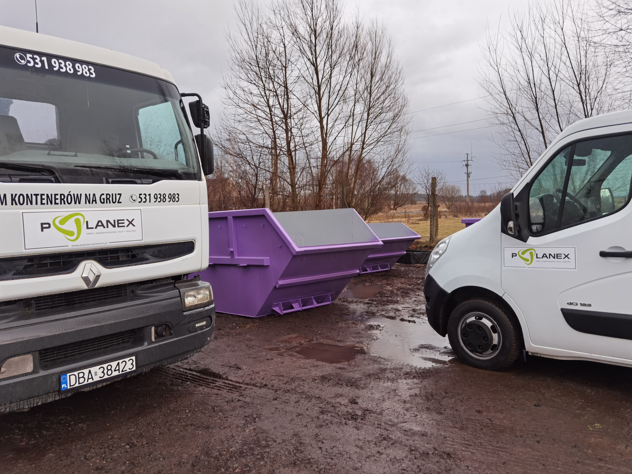 Dwa białe samochody dostawcze z logo firmy Planex stoją obok fioletowych kontenerów na gruz na błotnistym terenie w pochmurny dzień.