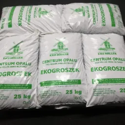 Ułożone w dwóch rzędach białe worki 25 kg z ekogroszkiem od Eko Miller Centrum Opału Anna Młynarz, z zielonym logo wiatraka i informacjami o parametrach.