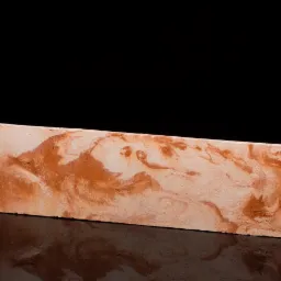 Prostokątna płytka imitująca marmur w odcieniach beżu i brązu, ułożona na czarnej, błyszczącej powierzchni, odbijająca światło.