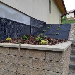 PROBUD Krzysztof Gołda - Budowa muru oporowego z kostki w Jedlinie-Zdroju, widoczna izolacja pionowa fundamentów oraz przygotowanie terenu pod nasadzenia.