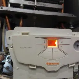 Wnętrze kotła gazowego Immergas EOLO STAR z widocznym płomieniem palnika i panelem sterowania z podświetlonym wyświetlaczem.