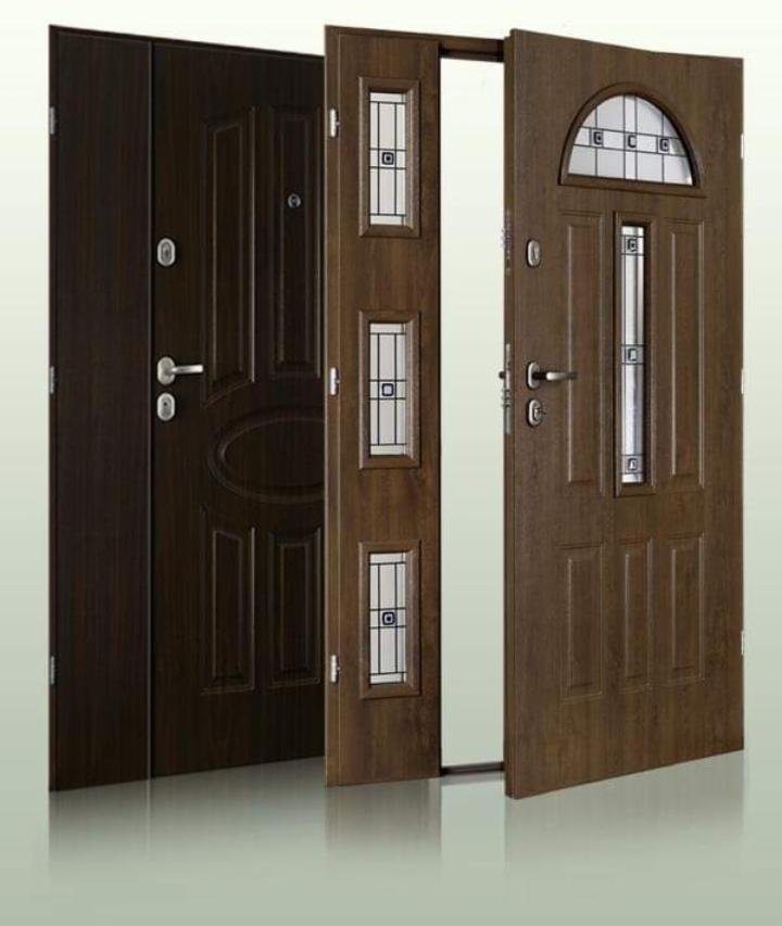Dwa modele drzwi wejściowych z przeszkleniami prezentowane przez firmę z Sosnowca, jeden otwarty, drugi zamknięty, w odcieniach brązu.
