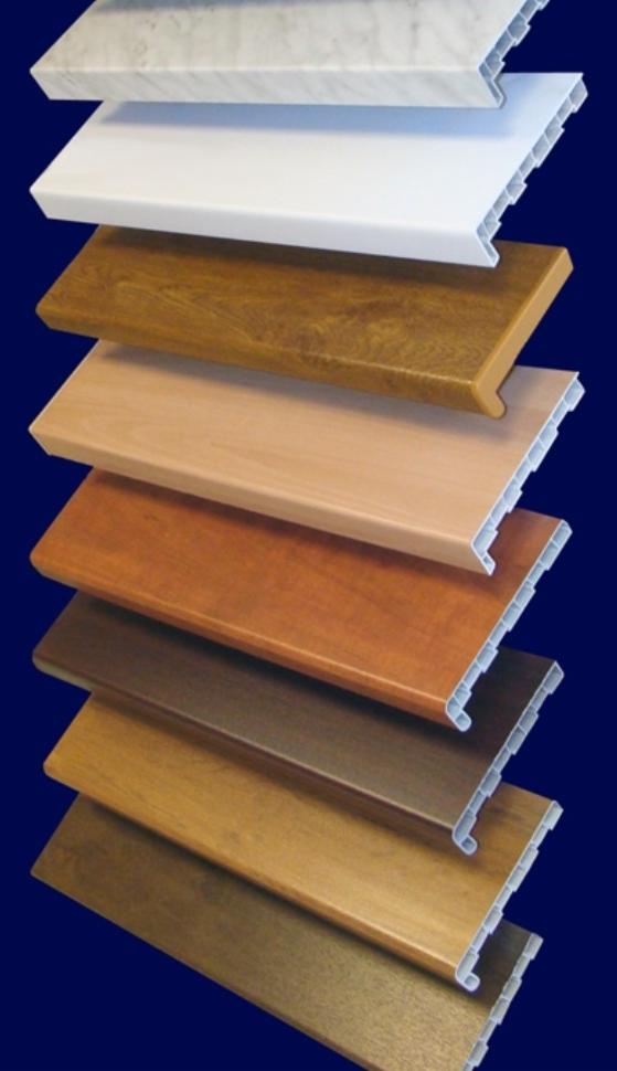 Przekrój różnych kolorów i wzorów parapetów okiennych z tworzywa sztucznego, ułożonych jeden na drugim na ciemnoniebieskim tle.