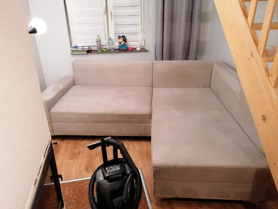 Beżowa kanapa narożna częściowo wyczyszczona z użyciem odkurzacza piorącego w domu w Wieprznicy, widoczne schody i okno z dekoracjami.