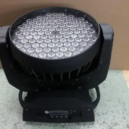 Czarny reflektor sceniczny LED z widocznym panelem sterowania i licznymi soczewkami, ustawiony na podłodze w pomieszczeniu.