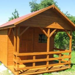 PPHU Ivbut - Gotowa, drewniana altana z zadaszeniem i balustradą, pomalowana na brązowo, z czerwoną dachówką, umieszczona na trawniku.