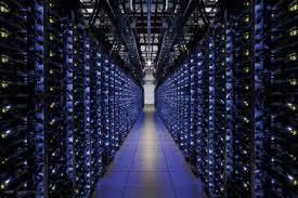 Wnętrze serwerowni z rzędami szaf rack, widok z perspektywy korytarza, niebieskie oświetlenie LED.