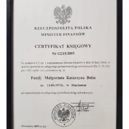 Oprawiony w czarną ramkę certyfikat księgowy wydany przez Ministra Finansów Rzeczypospolitej Polskiej, potwierdzający uprawnienia Małgorzaty Katarzyny Beim do usługowego prowadzenia ksiąg...