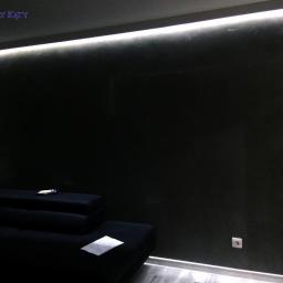 Cztery Kąty - Ciemna ściana z efektem dekoracyjnym oświetlona listwą LED, widoczny fragment czarnego narożnika i szara podłoga.