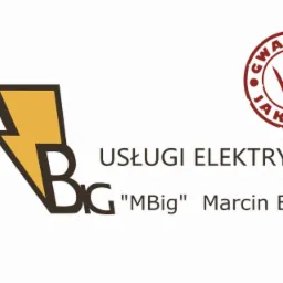 Logo firmy MBig Marcin Brzezoń oferującej usługi elektryczne, z symbolem błyskawicy i znakiem gwarancji jakości.
