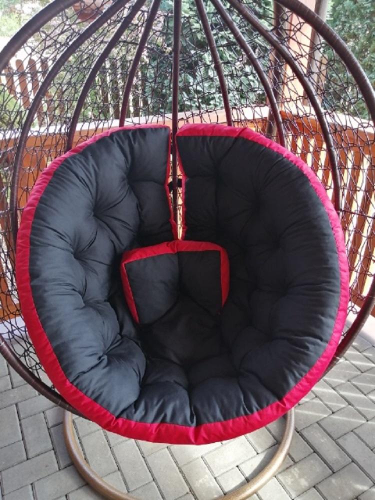 Kokon z poduszką w kolorze czarnym z czerwoną lamówką, wykonany w Koninie. Widoczny na tarasie.