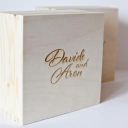 Inter-Gra Artur Szafran - Dwie jasne, drewniane skrzynki z wygrawerowanym laserowo napisem 'Davide and Aron' na froncie, widoczne połączenia na rogach.
