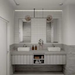 Elegancka łazienka z dwoma umywalkami nablatowymi, marmurowym blatem i szafką z ryflowanymi frontami. Nad umywalkami lustra i designerska lampa z okrągłymi kloszami. Na blacie dozowniki mydła...