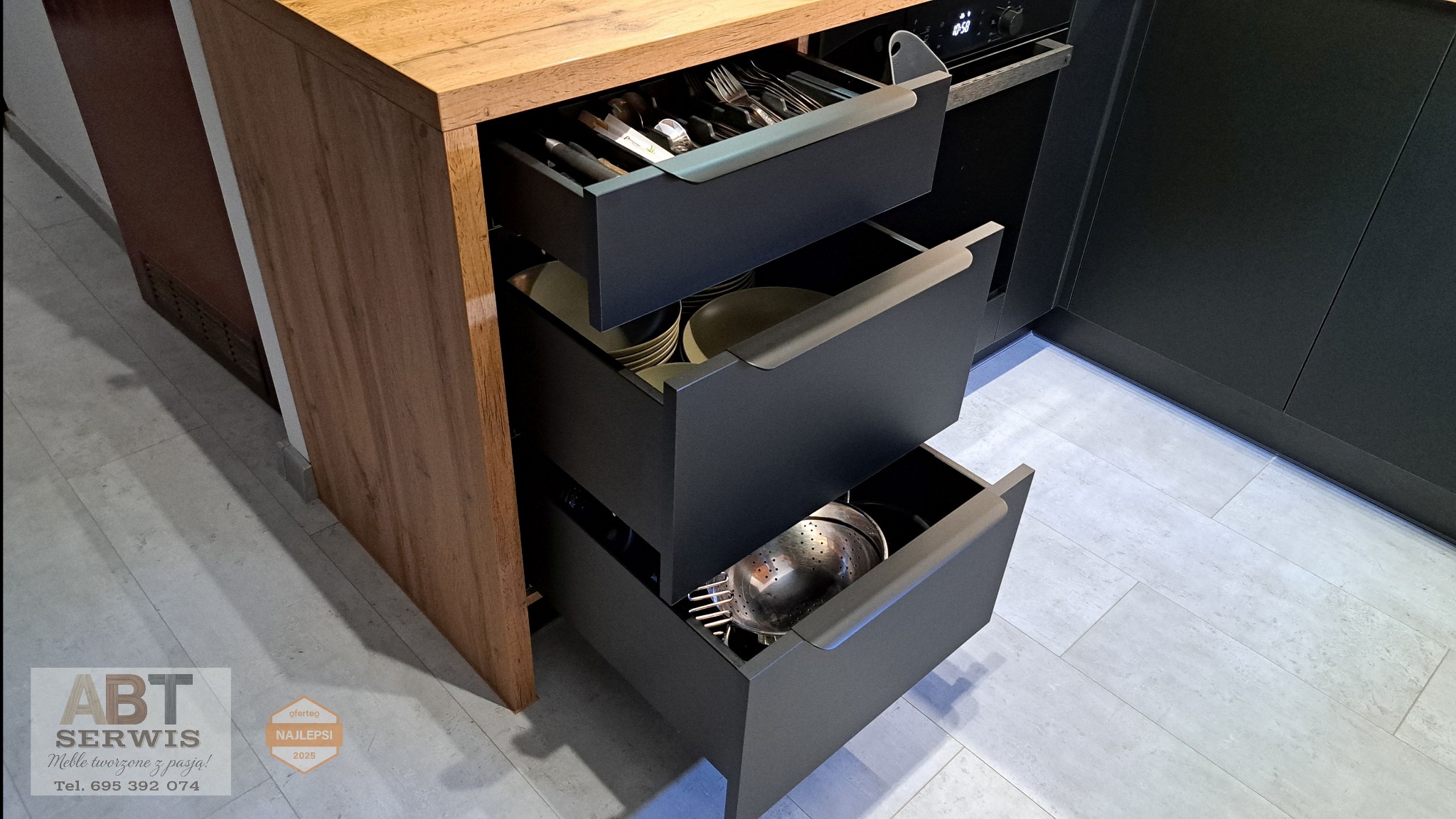 Szare szuflady kuchenne z drewnianym blatem: sztućce, talerze i durszlak. Nowoczesny design, funkcjonalność i porządek w kuchni, z bliska, z góry, oświetlenie dzienne.