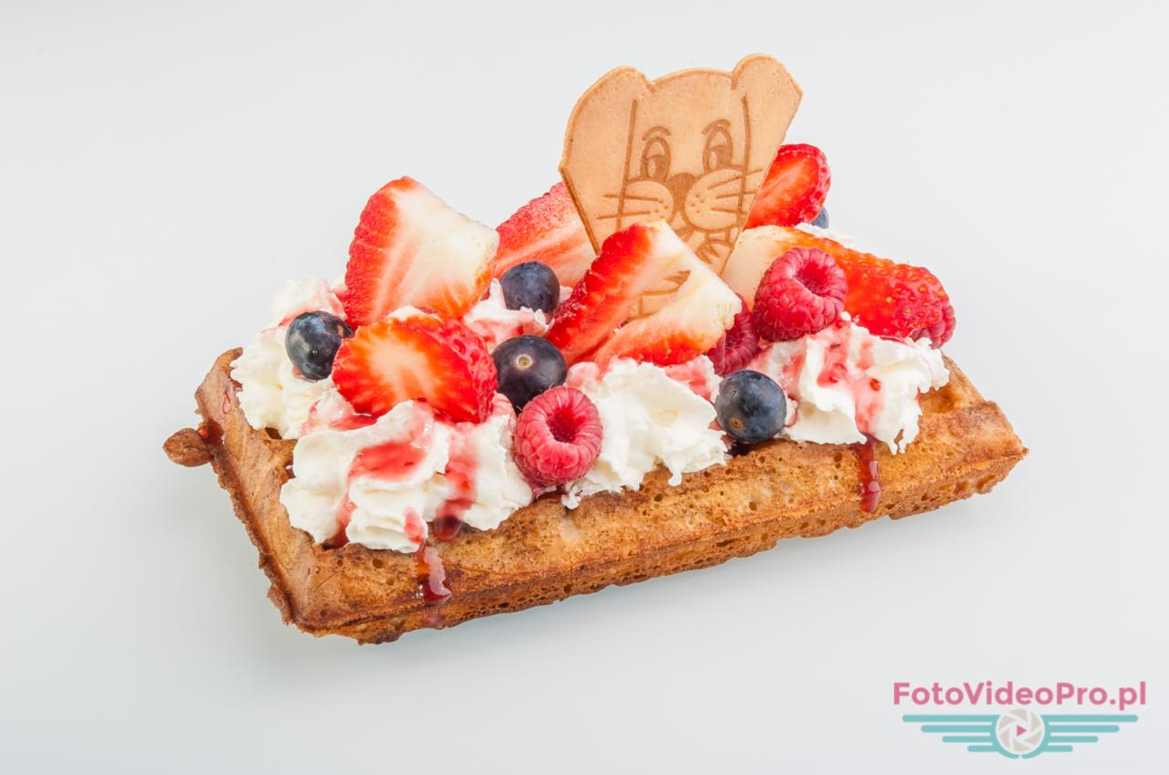 Belgijski gofr z bitą śmietaną, truskawkami, malinami, borówkami i waflem w kształcie głowy królika, polany sosem.