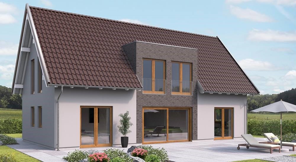 Elewacja domu z brązowym dachem, jasnymi ścianami i dużymi przesuwnymi oknami. Na tarasie leżaki i parasol. Widok na ogród i błękitne niebo.