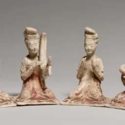 Cztery gliniane figurki muzyków z instrumentami, siedzące na kolanach, w tradycyjnych strojach z epoki dynastii Tang.