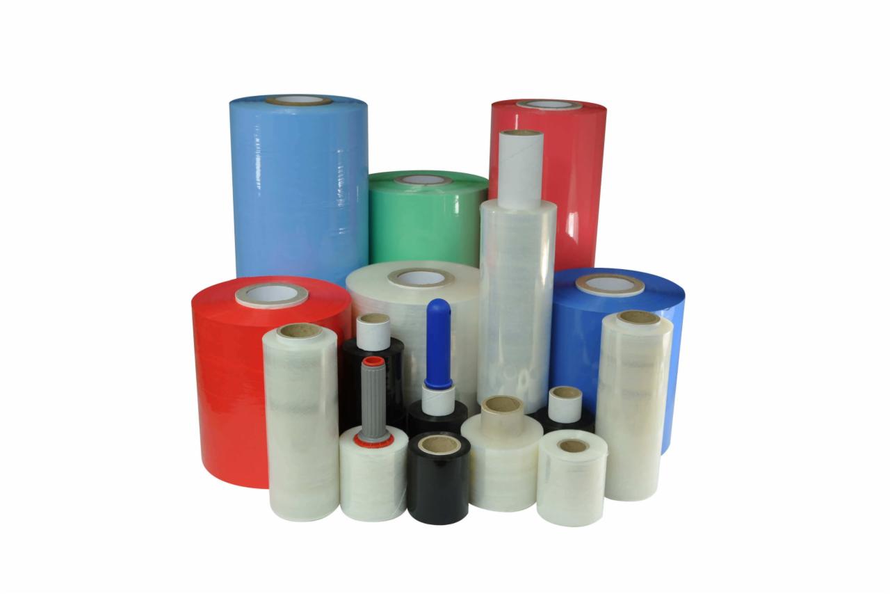 Różnokolorowe rolki folii stretch, niektóre owinięte wokół uchwytów, na białym tle.