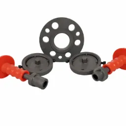 Zestaw przyrządów montażowych: okrągła tarcza z otworami i dwa uchwyty z czerwonymi rękojeściami, leżące na białym tle.