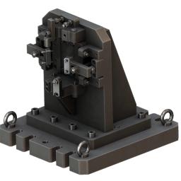 W-Metal Mateusz Warzybok - Szary, stalowy przyrząd obróbczy z licznymi śrubami i mocowaniami, osadzony na podstawie z uchwytami pierścieniowymi.