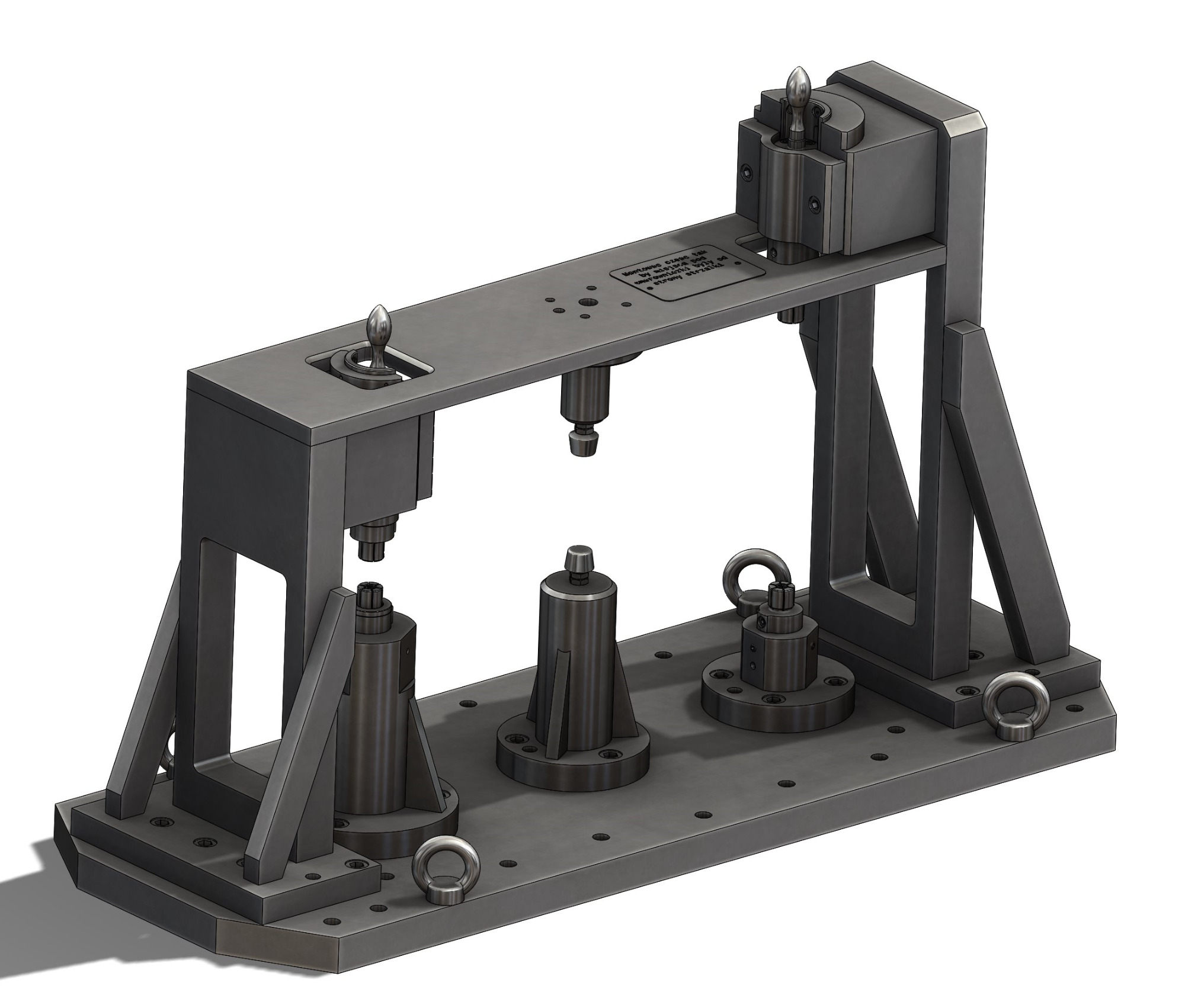 Wizualizacja 3D przyrządu obróbczego z metalu, z trzema cylindrycznymi uchwytami na podstawie i górną ramą, całość w szarym odcieniu z widocznymi śrubami i uchwytami do podnoszenia.
