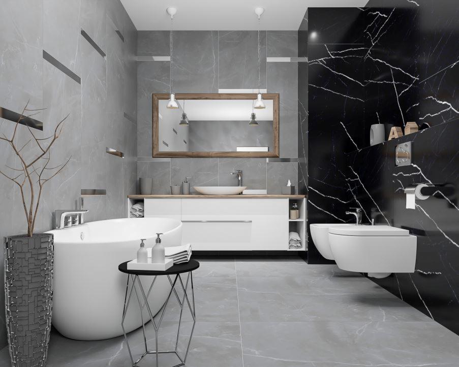 Elegancka łazienka z marmurowymi płytkami w odcieniach szarości i czerni, z wolnostojącą wanną, umywalką nablatową i toaletą wiszącą, oświetlona wiszącymi lampami.