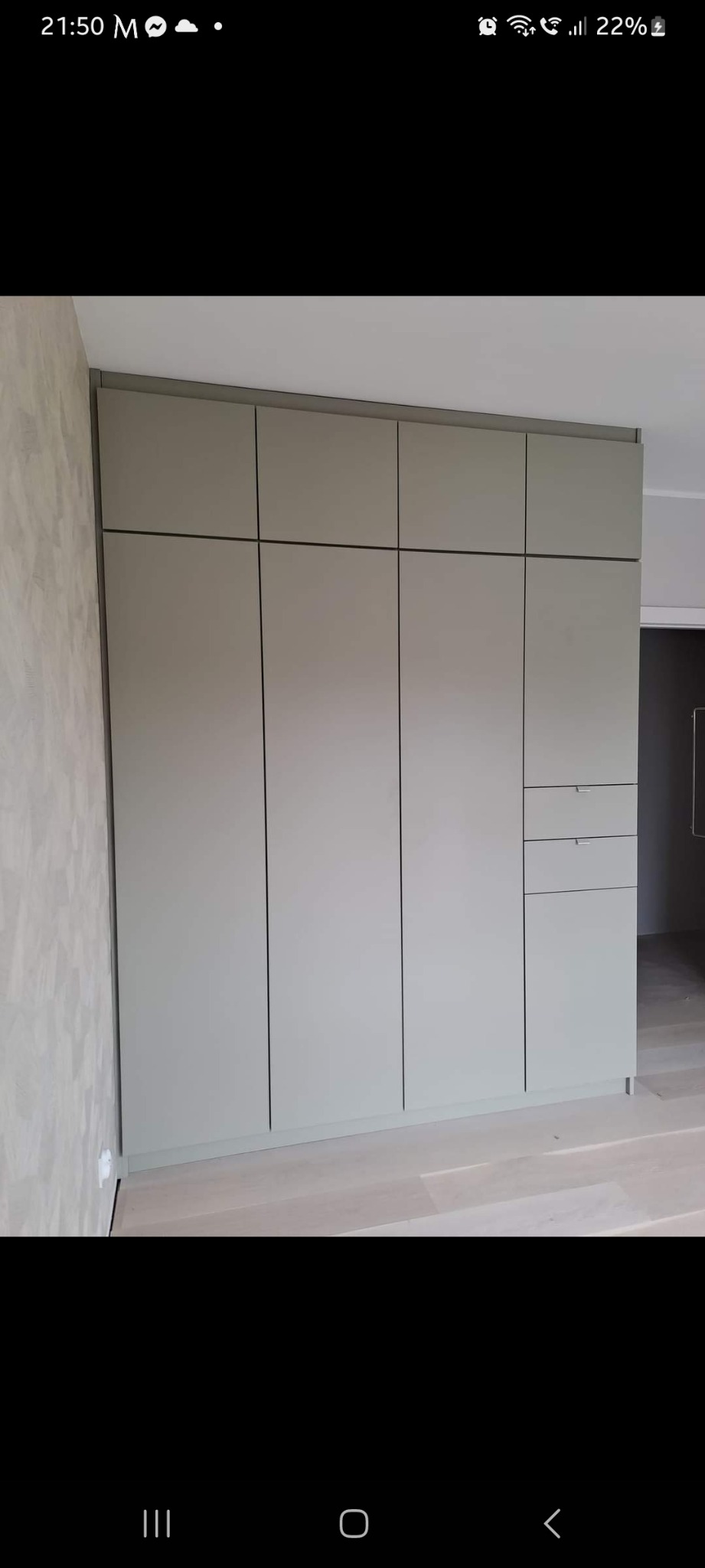 Pełna zabudowa kuchenna w odcieniach szarości, z trzema szufladami po prawej stronie, dopasowana do wysokości pomieszczenia.