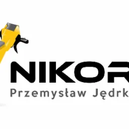 Logo firmy Nikors Przemysław Jędrkowiak z graficzną reprezentacją młota pneumatycznego otoczonego szarą strzałką.