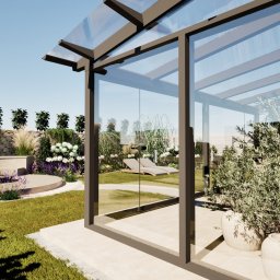 DREAMS DESIGN STUDIO - Wizualizacja ogrodu z przeszkloną altaną, z roślinnością w donicach i kamiennym murkiem. W tle leżaki. Jasne, słoneczne oświetlenie.