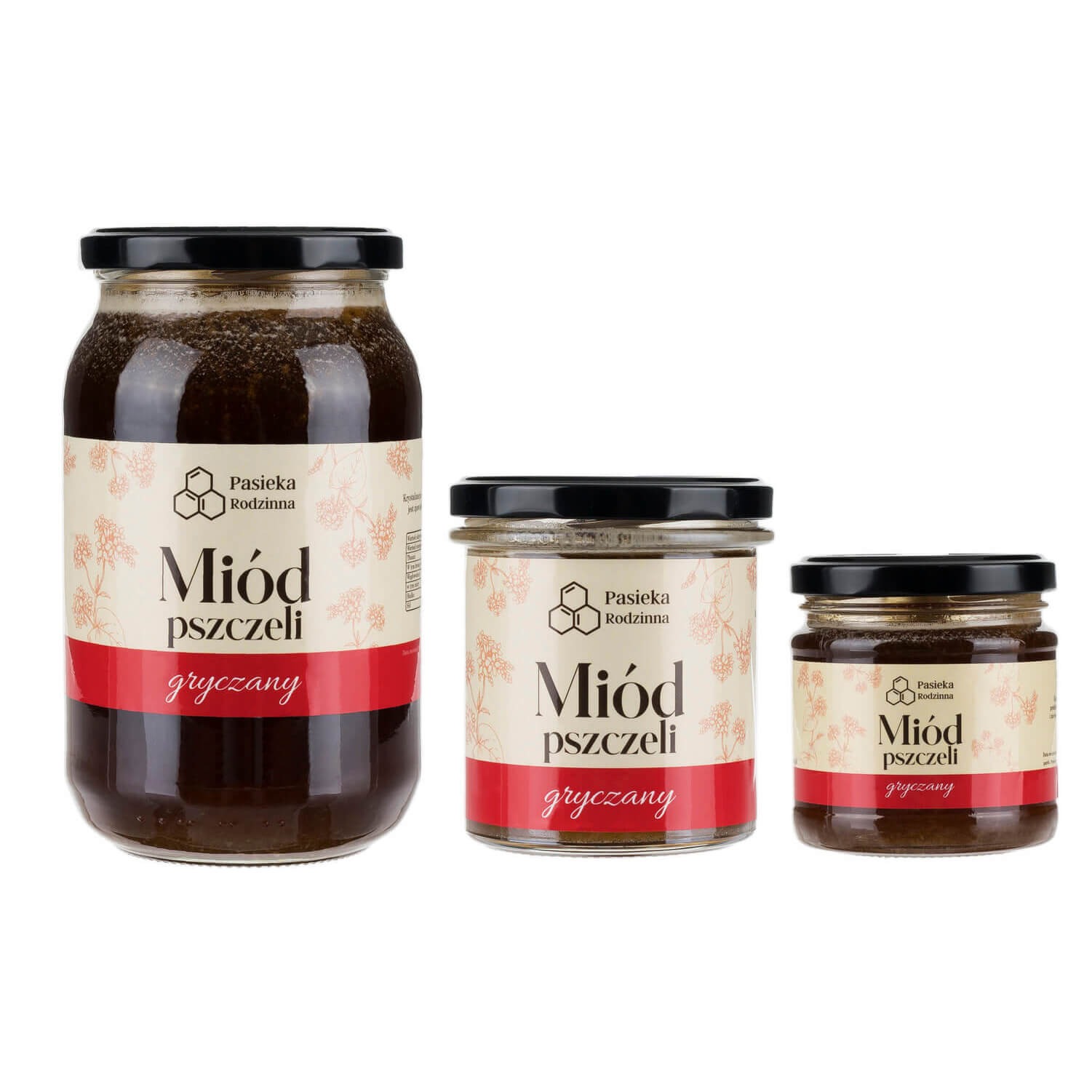 Trzy słoiki miodu gryczanego różnej wielkości z etykietami Pasieka Rodzinna, ustawione obok siebie na białym tle.