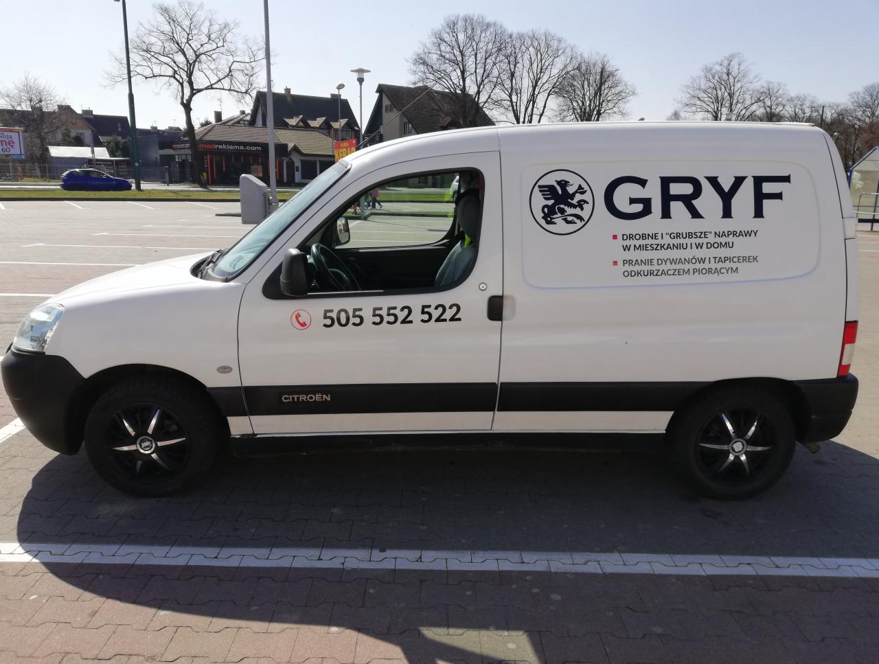 Biały samochód dostawczy Citroen z logo firmy 'GRYF' oferującej drobne naprawy w mieszkaniu i pranie dywanów, zaparkowany na parkingu.