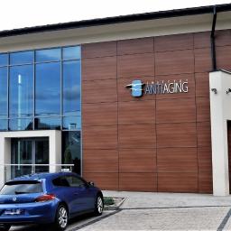 Omega Top Sp. z o.o. - Nowoczesny budynek z dużą szklaną fasadą, brązową elewacją z logo 'Instytut Antiaging' i niebieskim samochodem zaparkowanym przed wejściem.