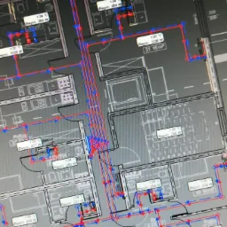 Rzut mieszkania z naniesionymi schematycznie instalacjami: grzewczą (czerwone linie) i wodną (niebieskie linie), widoczne oznaczenia temperatur i mocy grzejników.