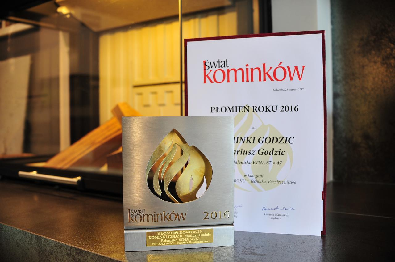 Nagroda 'Płomień Roku 2016' dla kominków Godzic, palenisko ETNA 67x47, kategoria Produkt Roku - Technika, Bezpieczeństwo, obok dyplom z tą samą nagrodą.