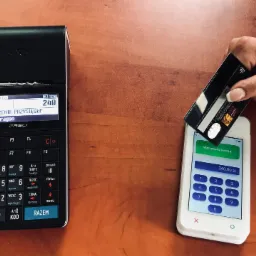 Uiszczanie opłaty za tłumaczenie przysięgłe kartą płatniczą na terminalu, widoczny paragon z napisem 'Tłumaczenie Przysięgłe' i kwota 240 zł.