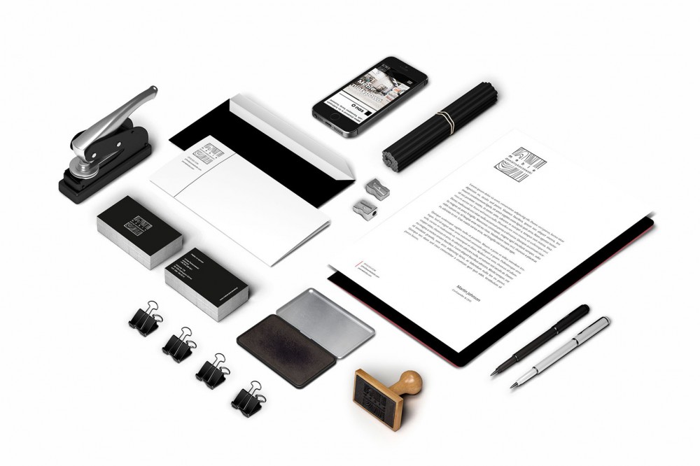 Mockup identyfikacji wizualnej firmy: wizytówki, papier firmowy, koperta, pieczątka, telefon z widoczną stroną internetową, długopisy i akcesoria biurowe na białym tle.