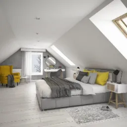 Jasne poddasze zaaranżowane jako sypialnia z łóżkiem, toaletką, żółtym fotelem i oknami dachowymi, utrzymane w stylu skandynawskim, z szarymi ścianami i drewnianą podłogą.