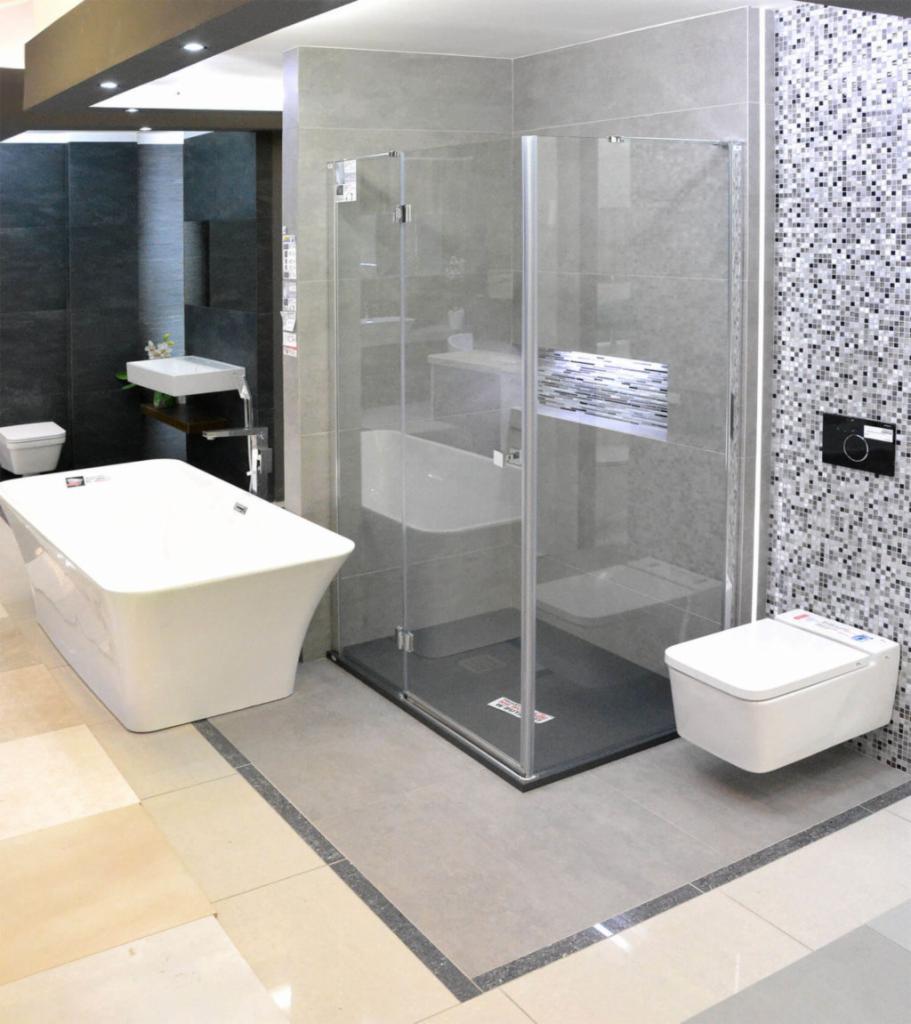 Nowoczesna łazienka z wolnostojącą wanną, kabiną prysznicową typu walk-in i wiszącą toaletą, wykończona mozaiką i szarymi płytkami w neutralnej kolorystyce.