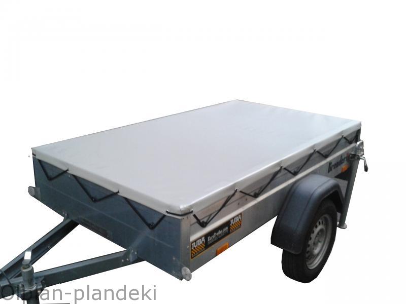 Przyczepa z zamontowaną szarą plandeką zabezpieczającą ładunek, widoczne mocowania plandeki i logo producenta przyczepy.