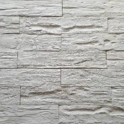 Biała ściana wykończona panelami imitującymi drewno o wyraźnej strukturze, ułożonymi w regularny wzór.