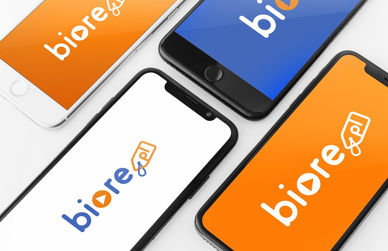 Cztery telefony z różnymi wersjami logo Biore.pl na ekranach: biały, czarny i pomarańczowy, ułożone pod kątem na białym tle.