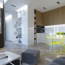 Wnętrze nowoczesnego apartamentu z otwartą kuchnią, jasnymi meblami i żółtymi krzesłami, widok z salonu na jadalnię i część kuchenną, minimalistyczny design.