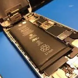 Otwarty smartfon z widoczną baterią Li-ion, podczas wymiany lub serwisu, na niebieskim podłożu.