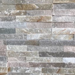 Anton Palianytsia ATOM - BUD - Ściana wyłożona dekoracyjnym kamieniem w odcieniach szarości, beżu i bieli, ułożonym w poziome pasy o nieregularnej fakturze.